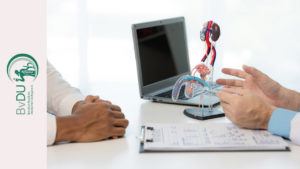 Arzt im Gespräch mit einem Patienten. Im Hintergrund ein Laptop und ein anatomisches Modell