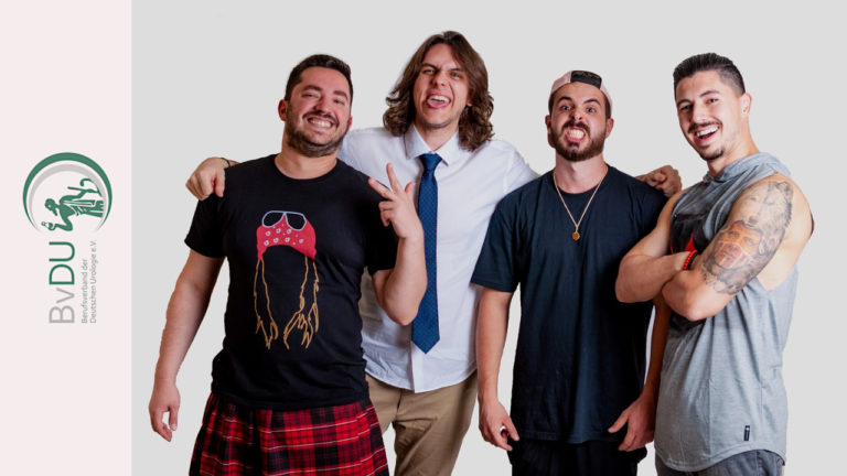 Vier lachende Männer mit unterschiedlichen Bekleidungsstilen.