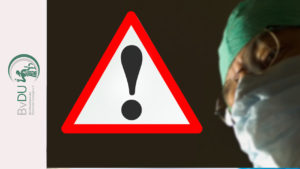 Seitlich das Gesicht eines Chirurgen, mittig ein Warnschild.